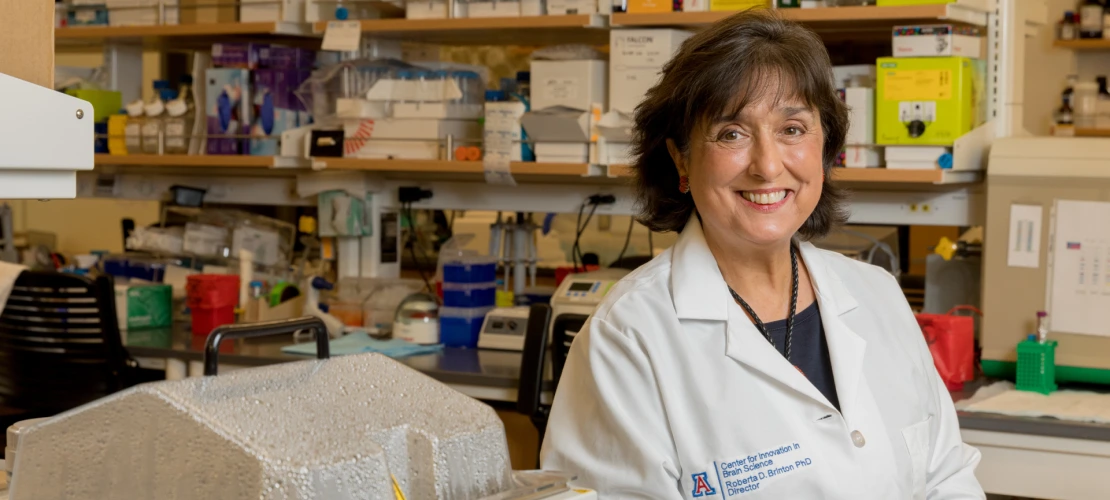 Dr. Brinton smiling facing the camera while in her lab