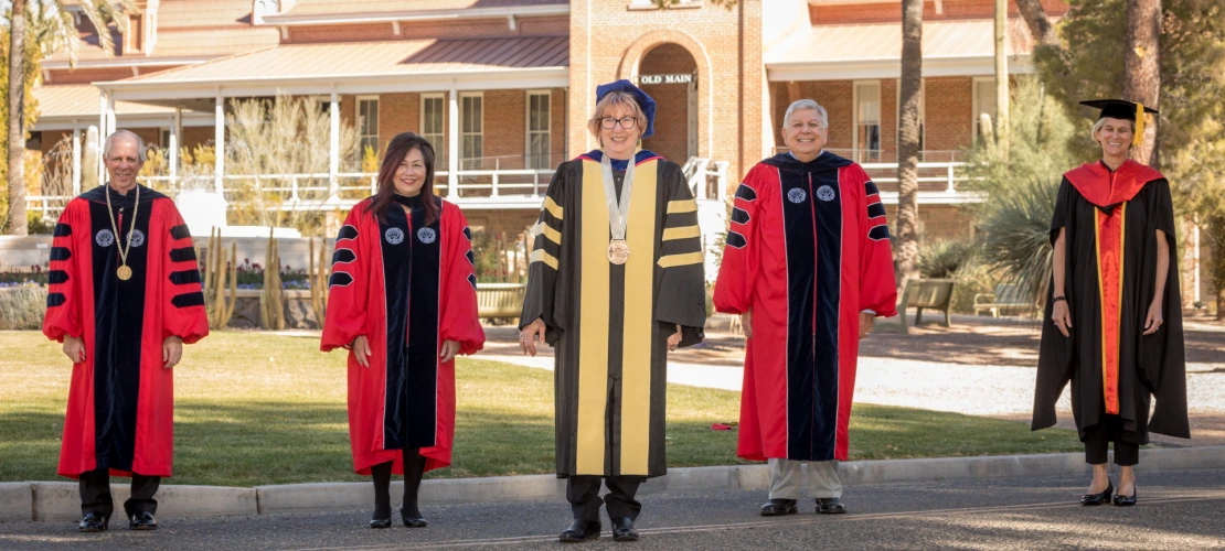 Dr. Brown posing with university leadership in front of Old Main