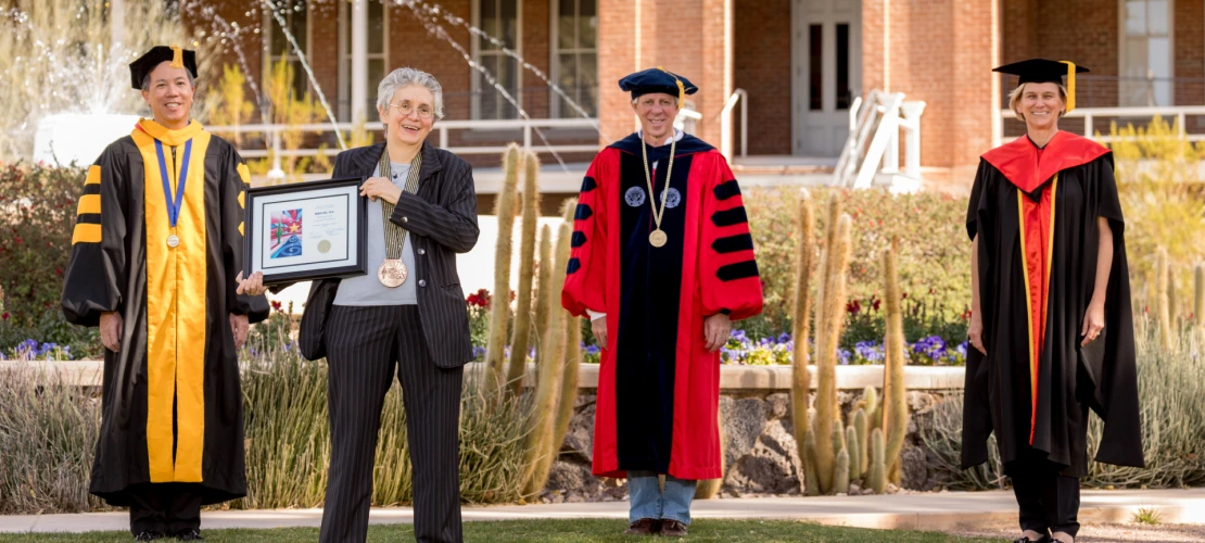 Mata Civil is seen posing with university leadership in front of Old Main