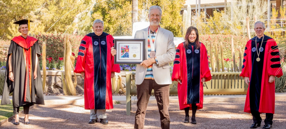 Alfred McEwen is seen posing with university leadership in front of Old Main