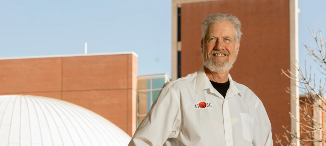 Alfred McEwen is seen smiling in front of the UArizona Planetarium