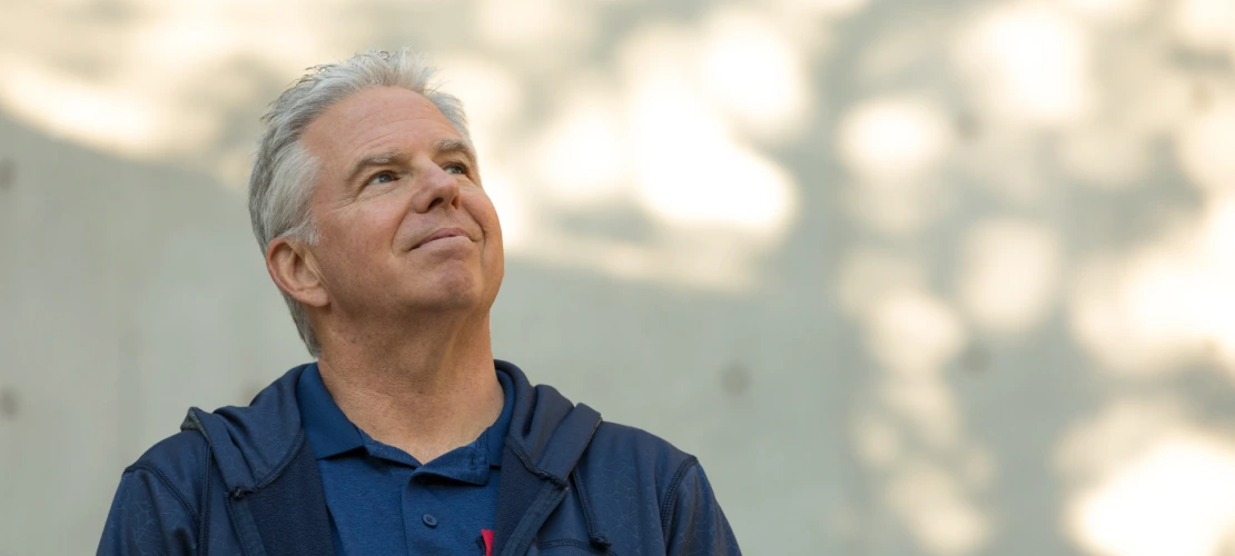 Jeff Stone poses near the steps of the Integrated Learning Center on campus