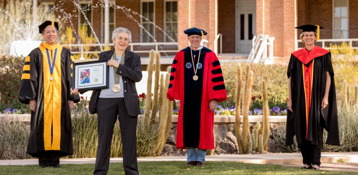 Mata Civil is seen posing with university leadership in front of Old Main