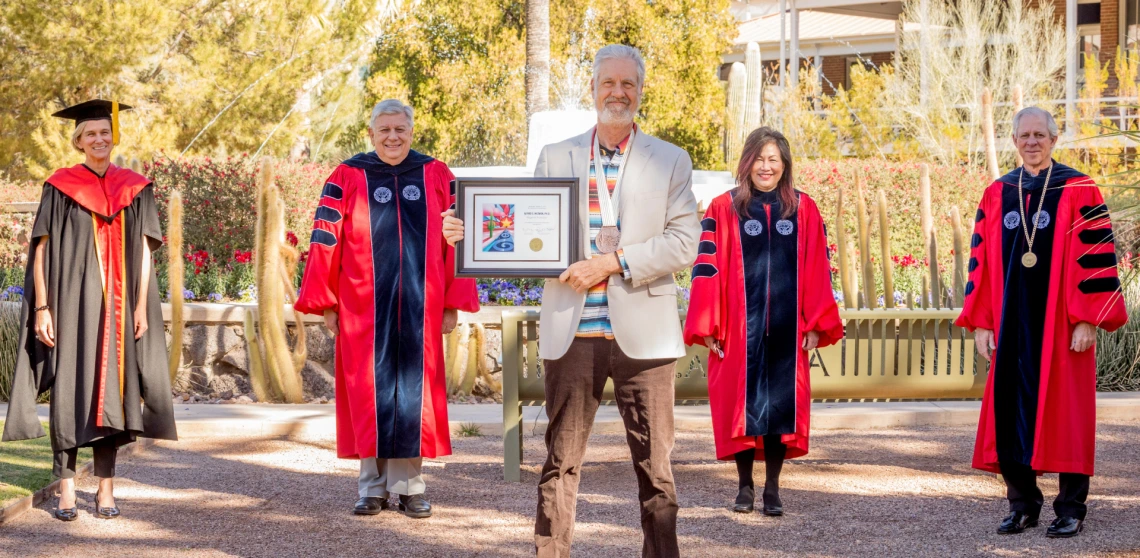 Alfred McEwen is seen posing with university leadership in front of Old Main