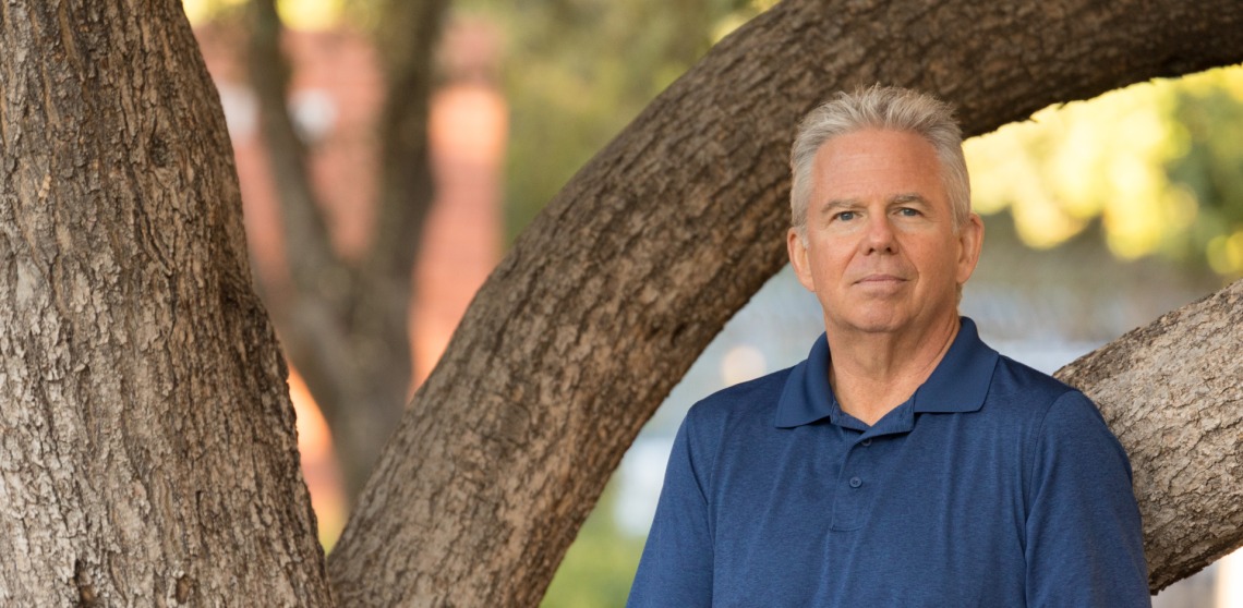 Jeff Stone is seen in front of a tree near the Psychology building on campus